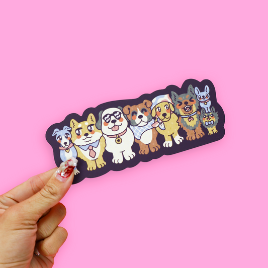 A die-cut sticker featuring a stacked arrangement of cute cartoon dogs in various breeds and colors, placed on top of an open pink book against a solid pink background.