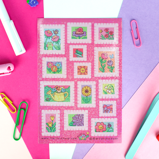 A hand holding a package of Turtle Soup Stickers against a solid pale yellow background. The package contains 12 colorful garden-themed stickers on a pink sheet with a yellow header card.