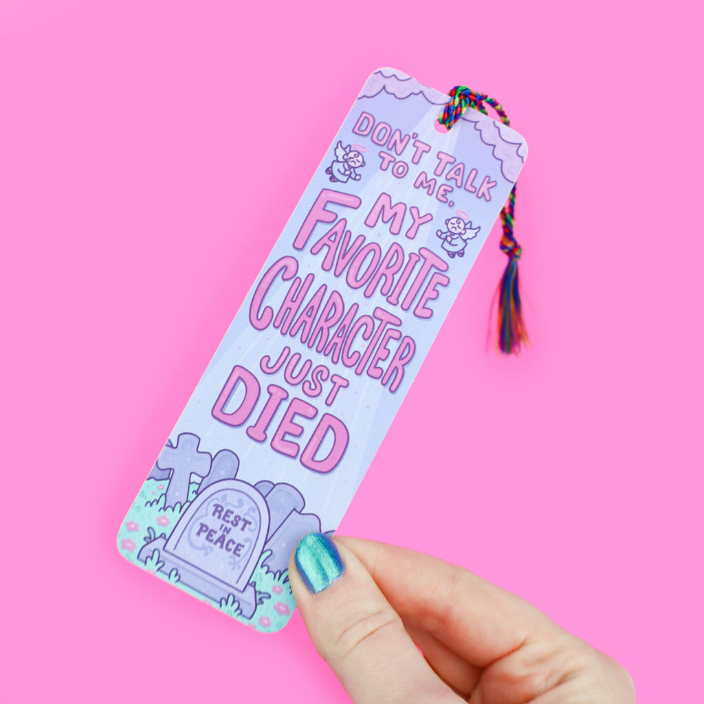Bookmark with rainbow tassel featuring a graveyard with the text 'Don't talk to me, my favorite character just died'