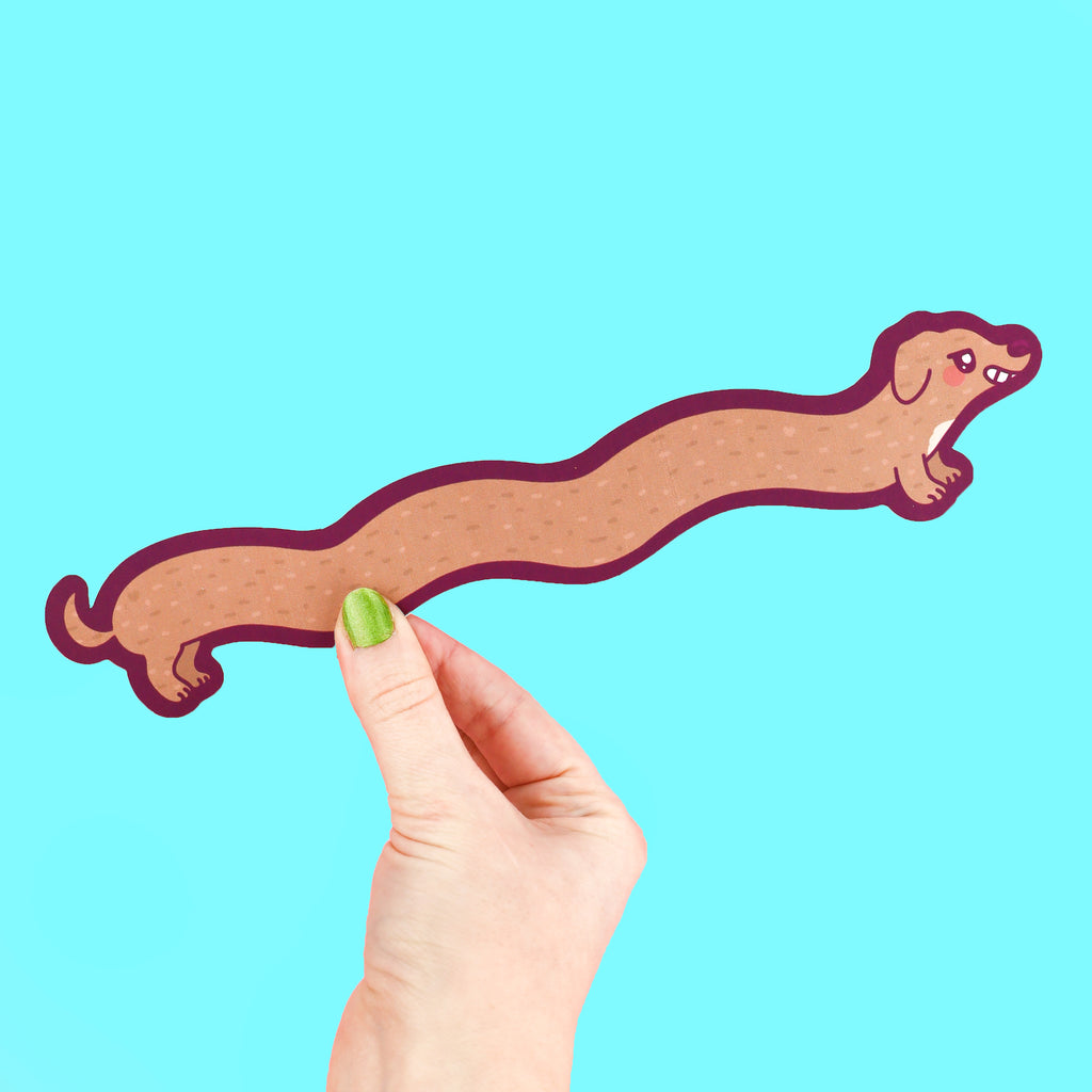 Long bookmark shaped like a weenie dog with a happy smile