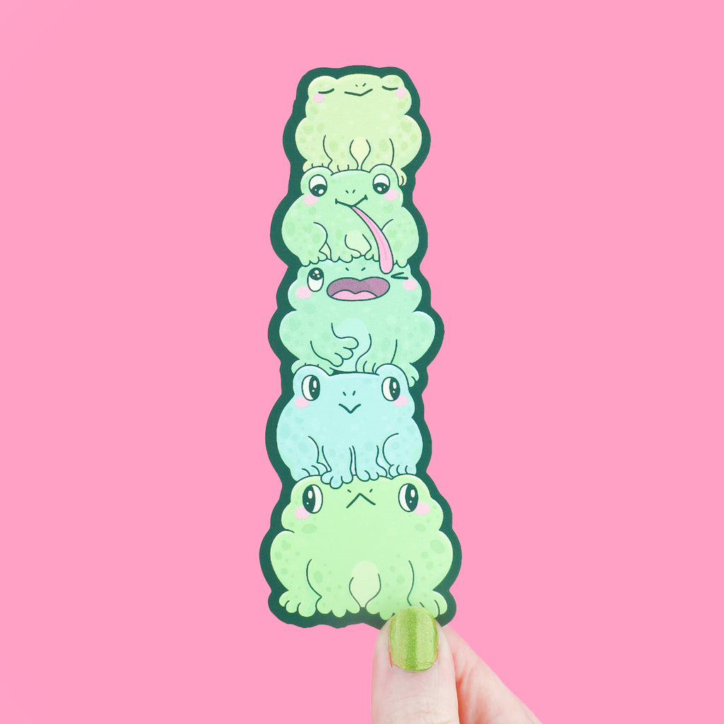 A bookmark shaped like a stack of frogs with cute expressions