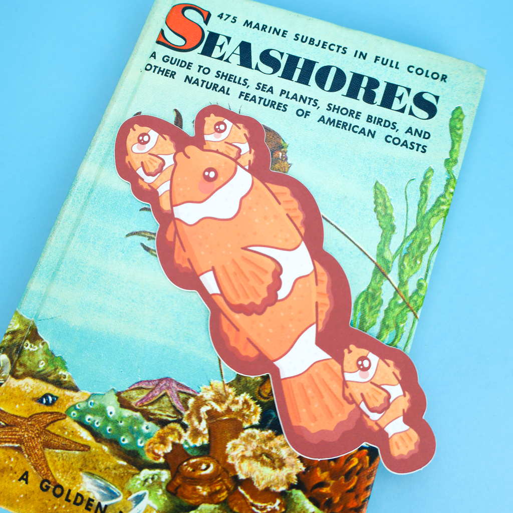 A vintage children's book titled "Seashores" by Golden, featuring a colorful underwater illustration with clownfish on the cover, photographed against a solid light blue background.