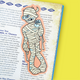 A vintage illustrated book page featuring a cartoon character wrapped in bandages, with text columns on both sides and a bright yellow background visible at the edges.