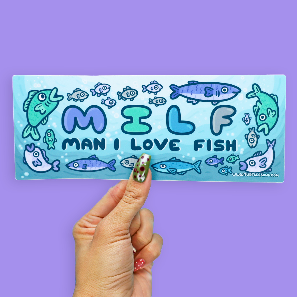 A hand holds a rectangular sticker against a solid purple background. The sticker features a light blue watercolor-style background with cartoon fish and the text 'MILF MAN I LOVE FISH' in blue and teal lettering.