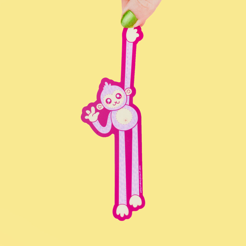 Long sticker shaped like a monkey hanging from something high while giving a wave