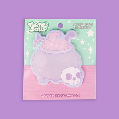 A package of 'Turtle's Soup' brand sticky notes featuring a cute pastel purple cauldron with pink potion and a small white skull, presented on a mint and pink backing card against a solid purple background.