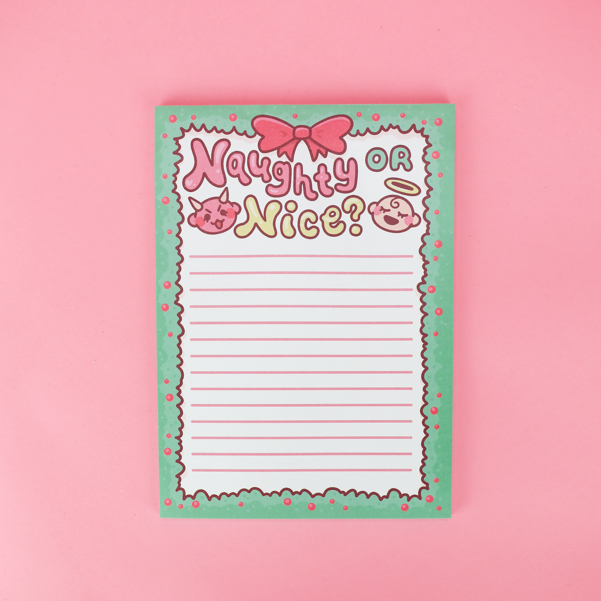 A cute, cartoon-themed lined notepad with the text 'Naughty or Nice?' in pink and yellow lettering, decorated with a pink bow, pig illustrations, and a scalloped mint green border, set against a solid pink background.