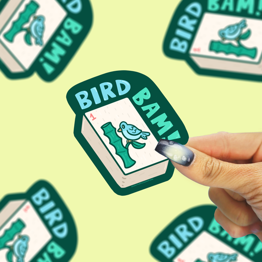 photo of a bird bam mahjong vinyl sticker being held against a yellow back drop