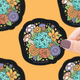 Decorative sticker with a D20 die surrounded by flowers on a yellow background