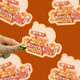 Kitten Nuggets vinyl sticker being held by a hand with a brown background