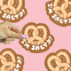 Hand holding a 'I'm Salty' pretzel-shaped sticker against a pink background with more stickers.