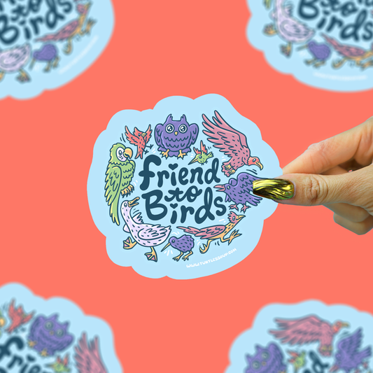 A hand with gold nail polish holds a die-cut sticker that reads 'Friend to Birds' surrounded by colorful illustrated birds on a light blue cloud-shaped background. The sticker is centered against a coral-pink background with partial duplicate sticker images around the edges.