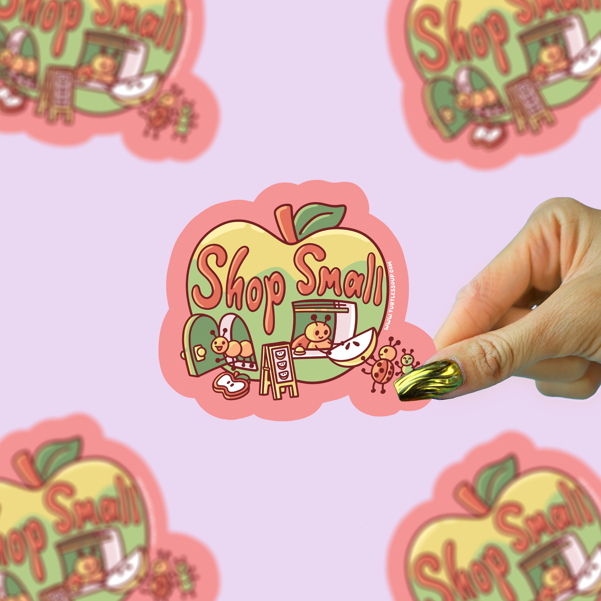 Sticker with 'Shop Small' design on a pink background, with a hand holding a gold marker.