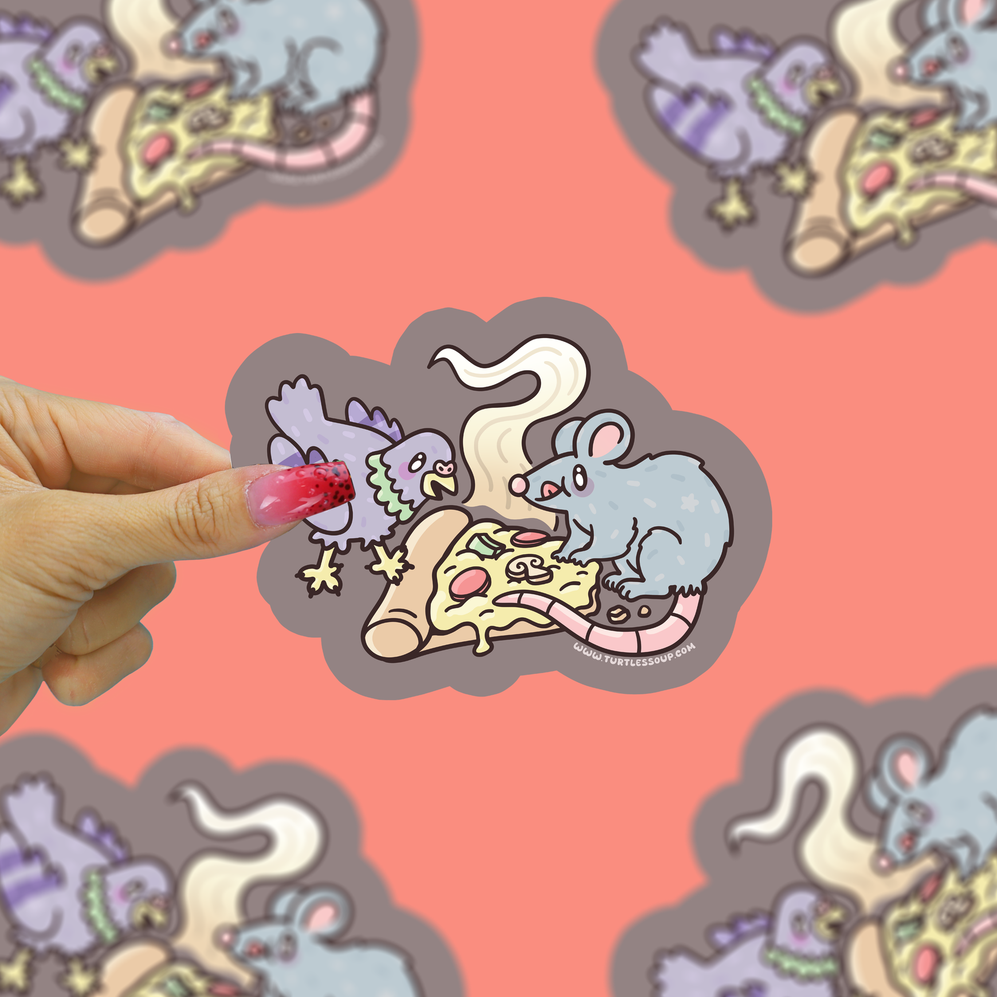 Hand holding a sticker with cartoon mice eating pizza against a patterned background