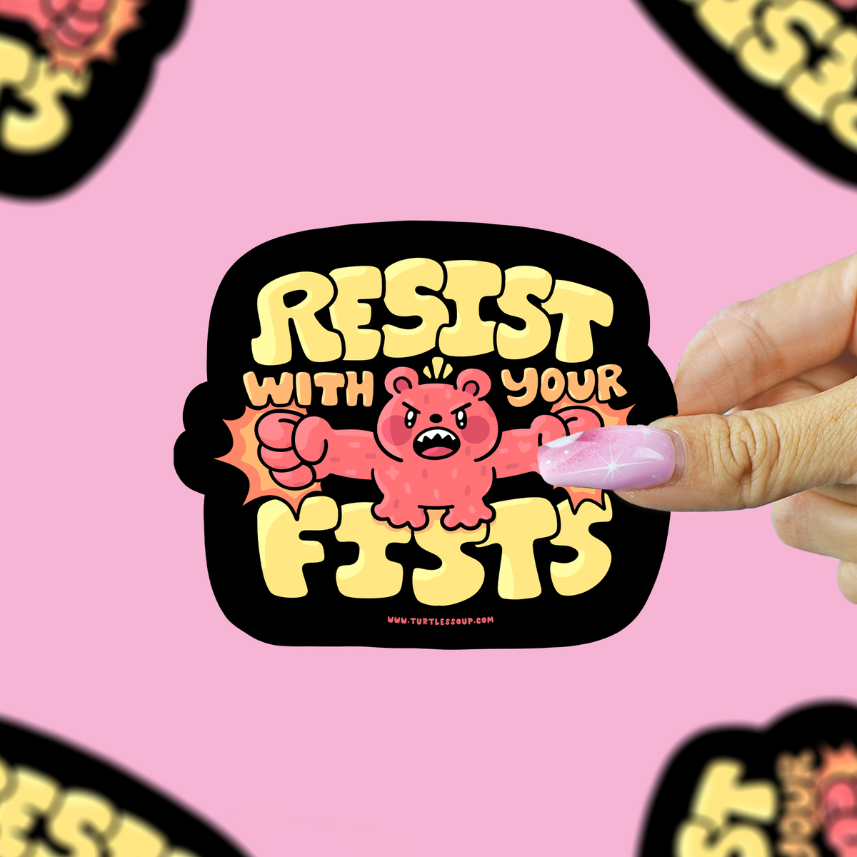 A hand holds a die-cut sticker featuring a pink cartoon bear with clenched fists and the text 'RESIST WITH YOUR FISTS' in yellow on a black background. The sticker is centered against a pink backdrop with several blurred copies of the same sticker around the edges.