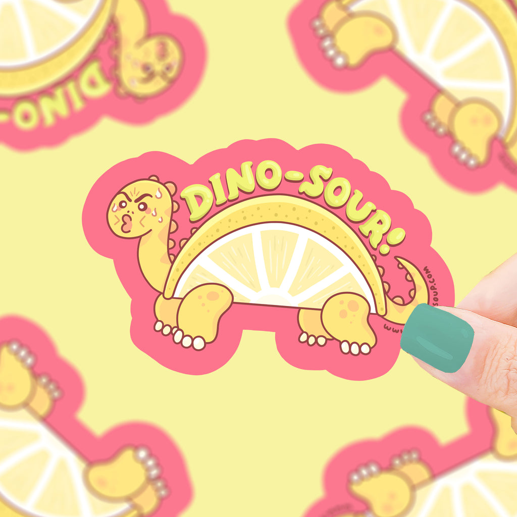A yellow dinosaur making a sour expression with a lemon slice for a body, text says "dino-sour!"