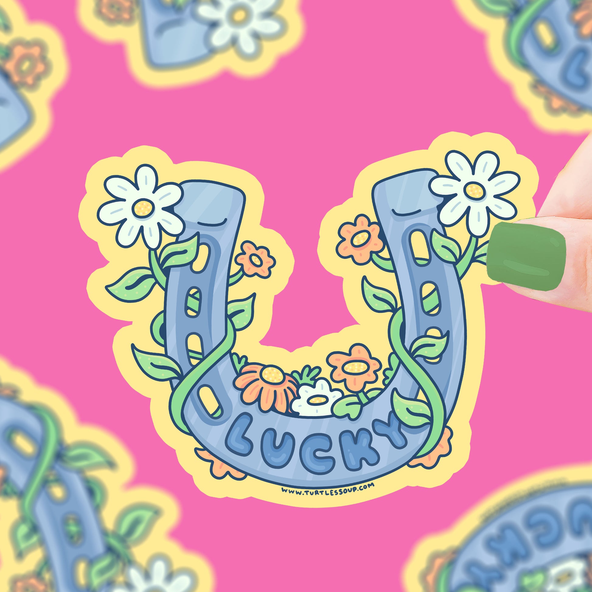 A silver horseshoe covered with daisies. Text on horseshoe says "lucky"