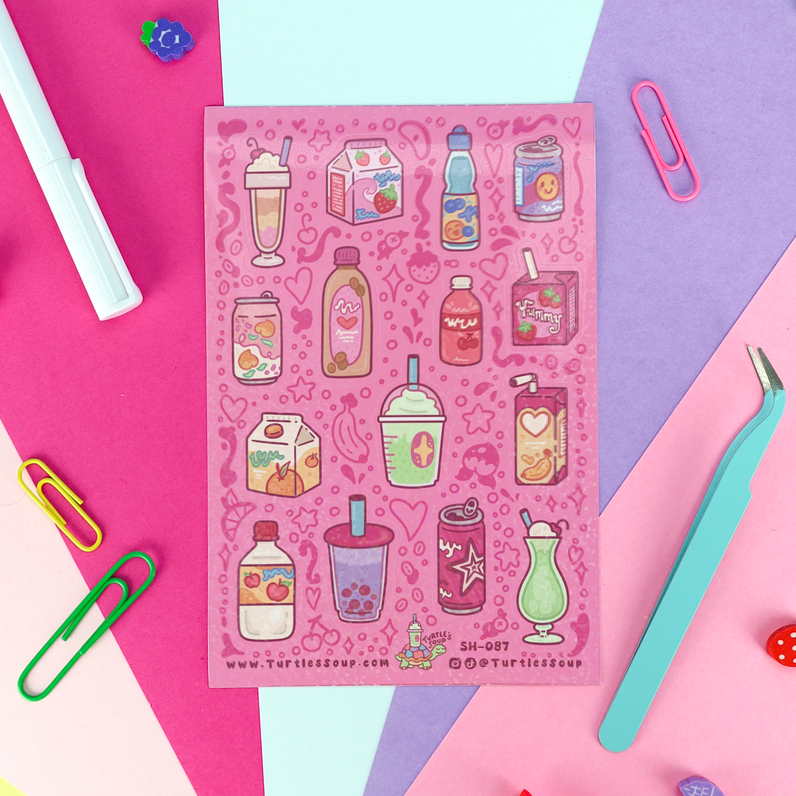 A pink sticker sheet featuring cute illustrations of various milk drinks, smoothies, and juice boxes, styled in a flat-lay on a geometric background of pink, purple, and light blue paper with office props.