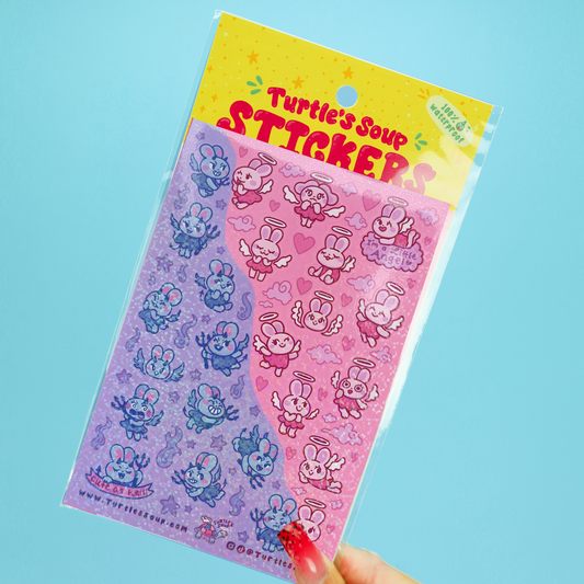 A hand with red nail polish holds a clear plastic package of 'Turtle's Soup Sticker' featuring cute cartoon angel turtles on a split purple and pink background, set against a solid light blue backdrop.