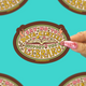 A hand with pink glittery nails holds a die-cut sticker that reads 'SAY-NO TO DATA CENTERS SUPPORT THE LIBRARY' with an open book and floral design. The background is a bright turquoise with partial duplicate views of the same sticker at the edges.